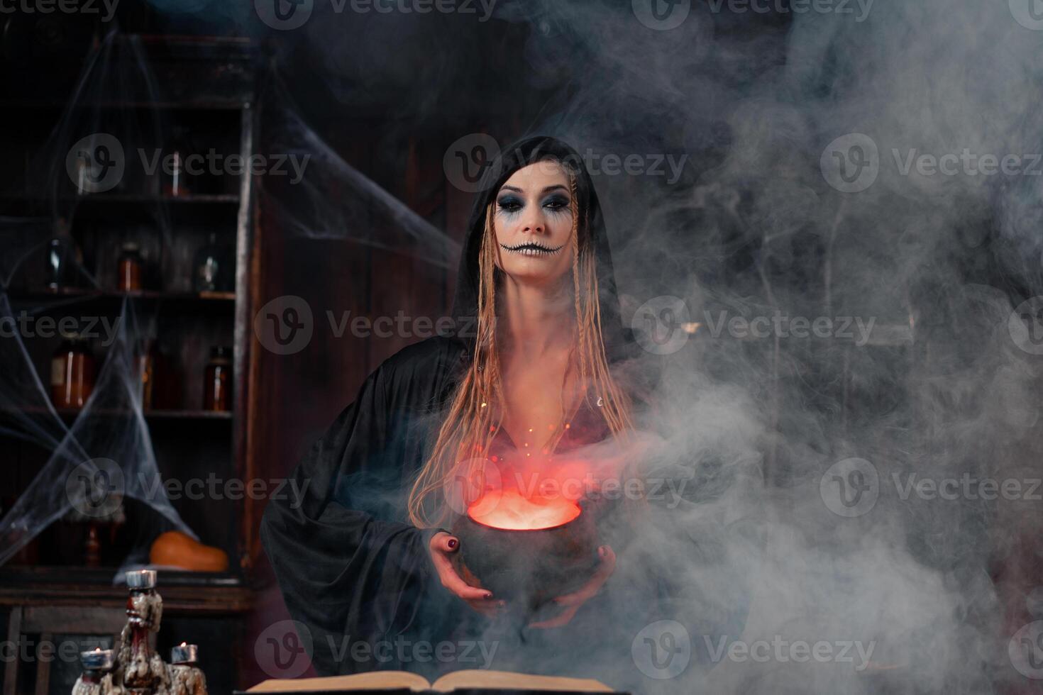Halloween, witch use magic book and cauldron prepare poison or love potion photo