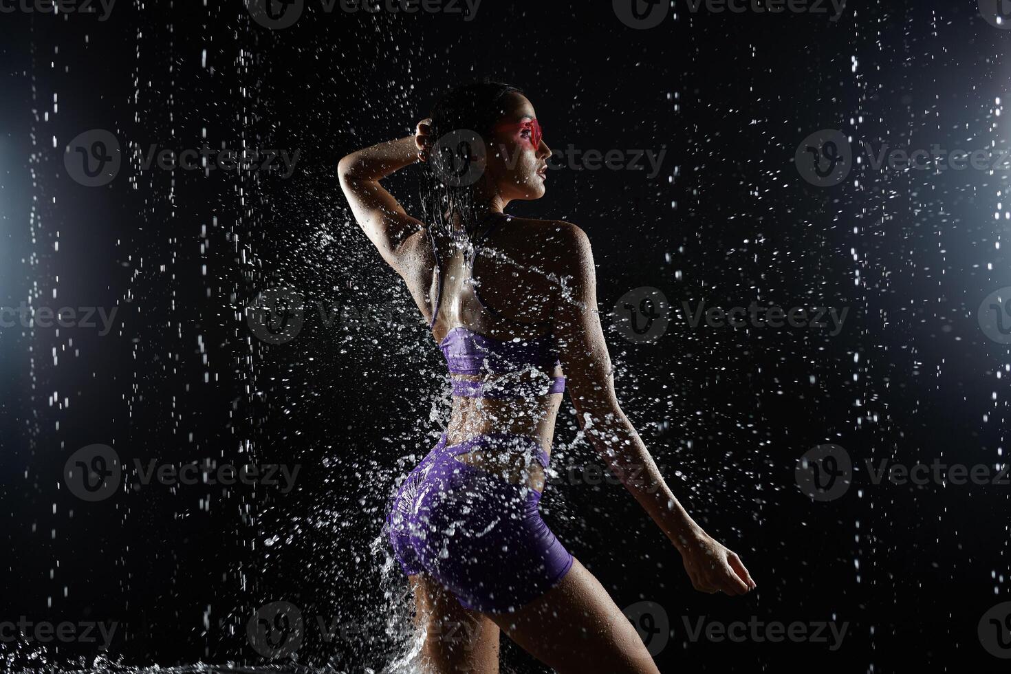 Beautiful athletic caucasian girl with a perfect figure is standing under the water. Fitness woman in a spray of water. Sports freshness. concept photo