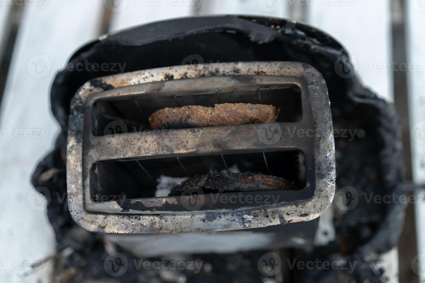 Burning toaster. Toaster with two slices of toast caught on fire over white background photo