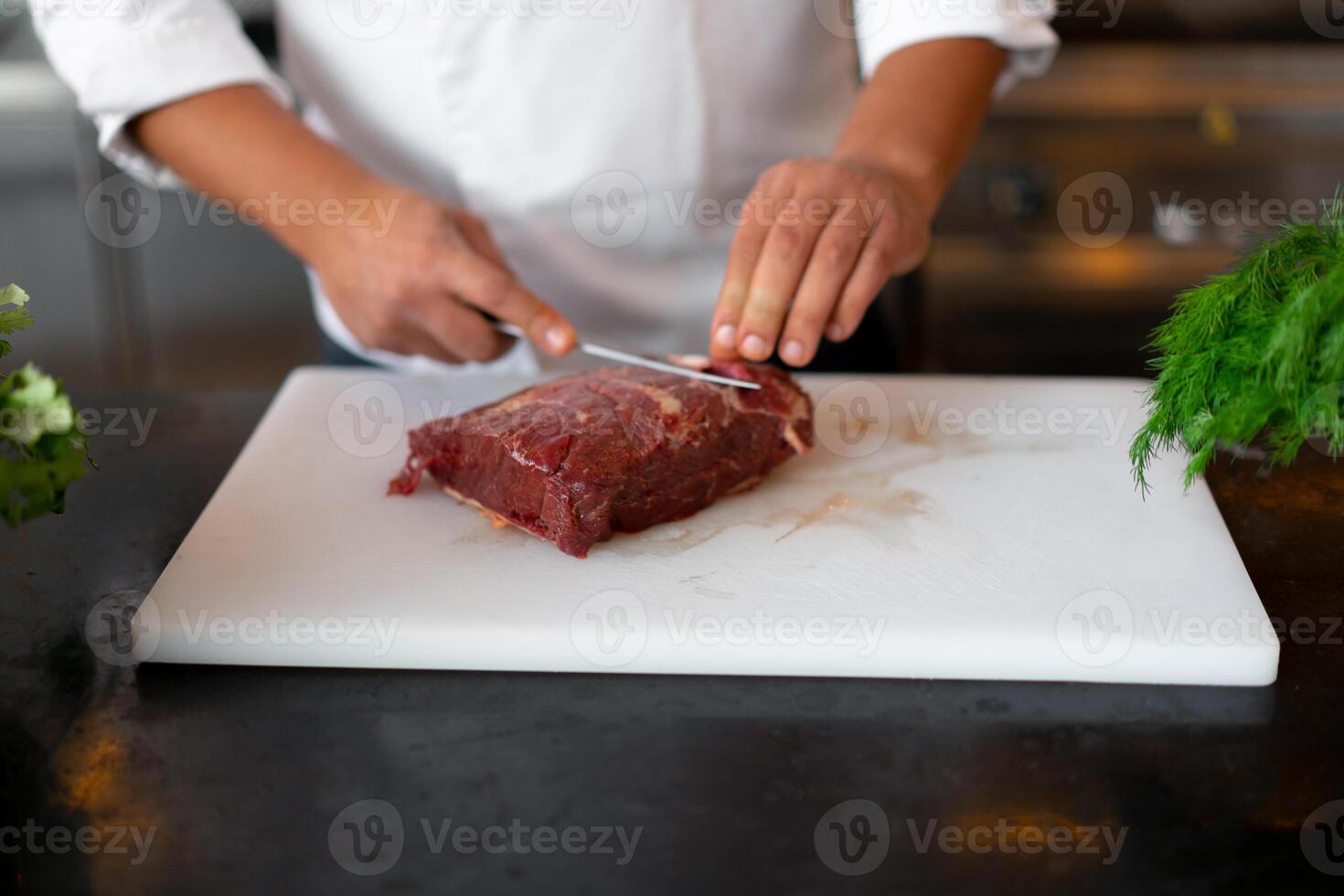 irreconocible joven africano cocinero en pie en profesional cocina en restaurante preparando un comida de carne y queso vegetales. foto