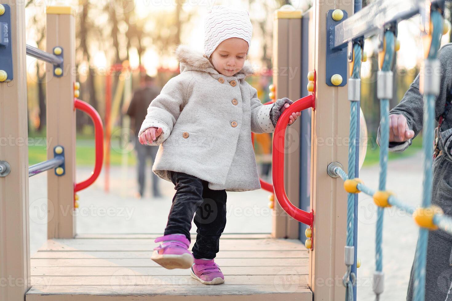 little cute girl playing at the playground in autumn photo
