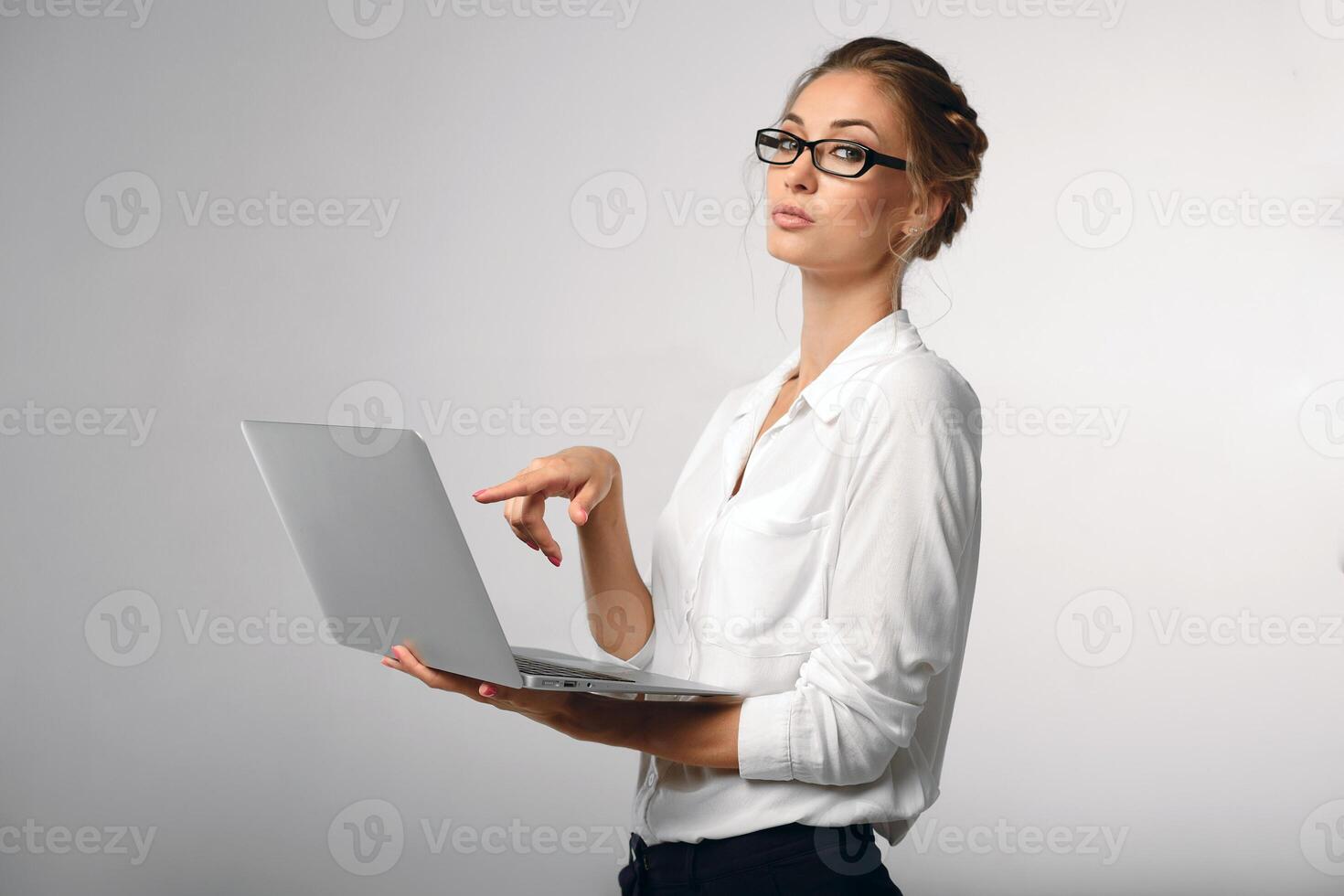 beautiful girl in a white office shirt shows on the laptop screen photo