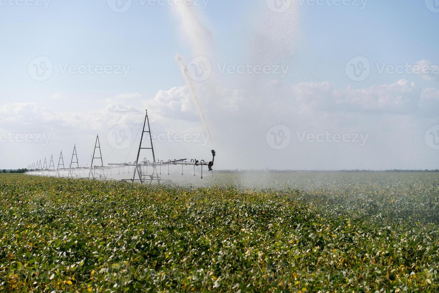 Irrigation System Watering Crops on Farm Field. photo