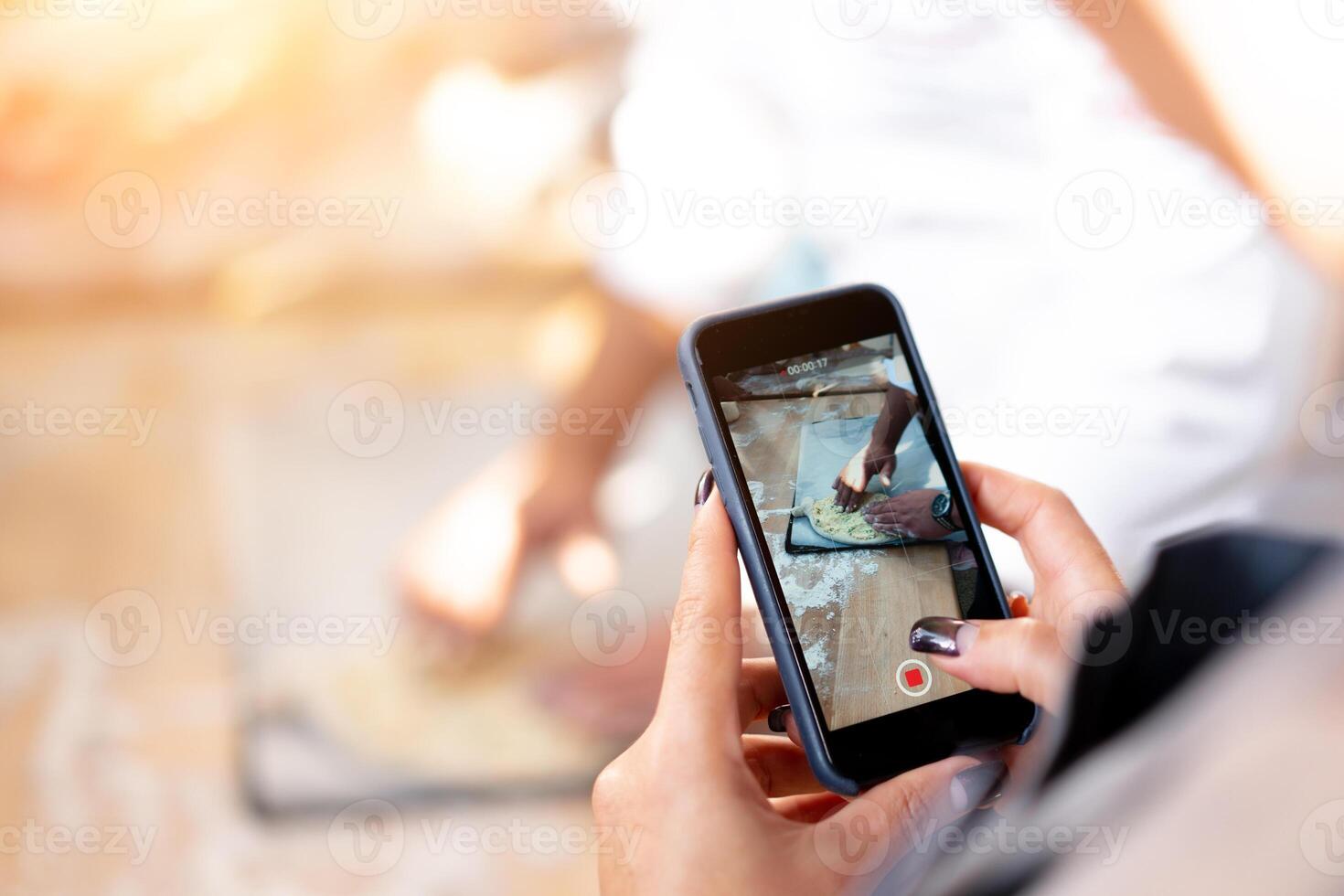 A woman shoots the khachapuri preparation process on the mobile phone. Closeup photo. Space for text photo