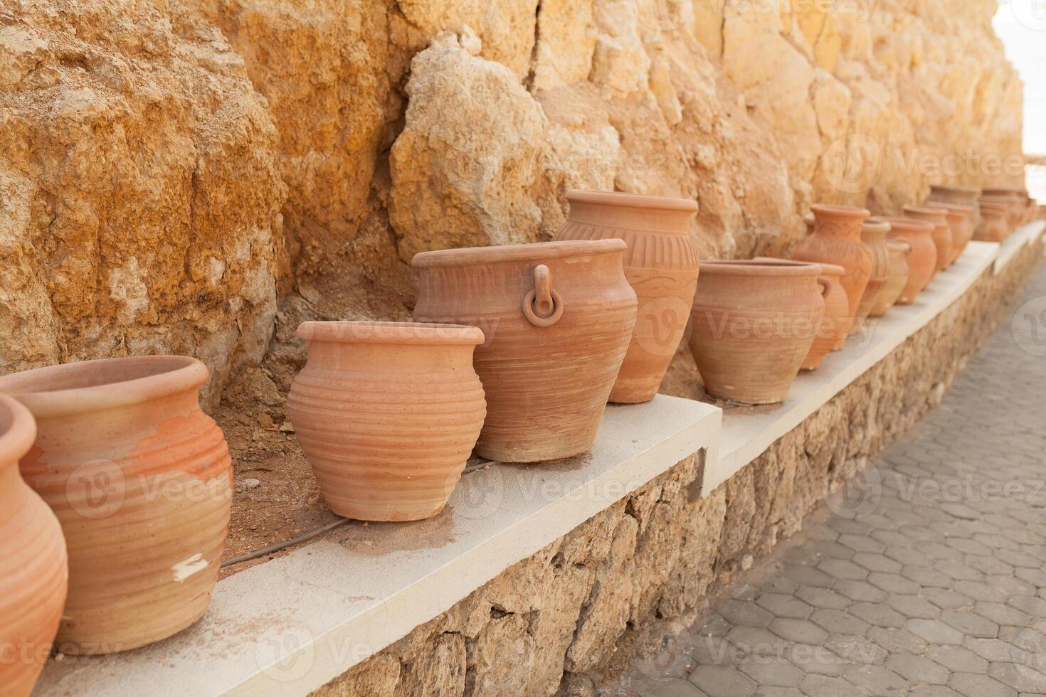 many large clay pots standing in a row photo