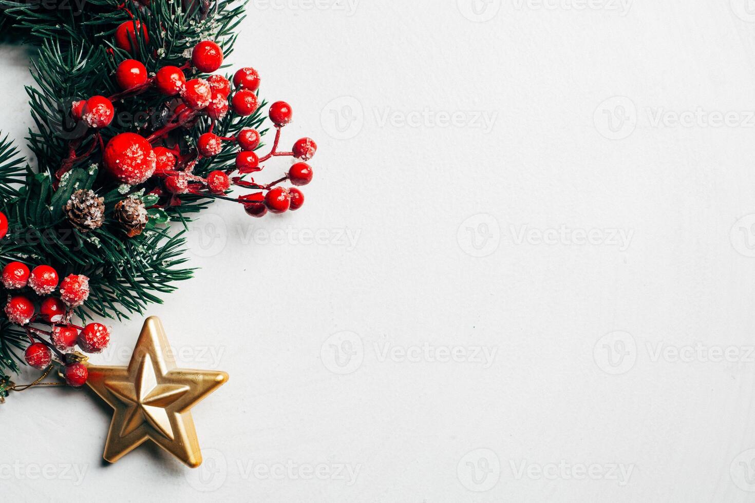 Christmas decorative wreath of holly, ivy, mistletoe, cedar and leyland leaf sprigs with red berries over white background. photo