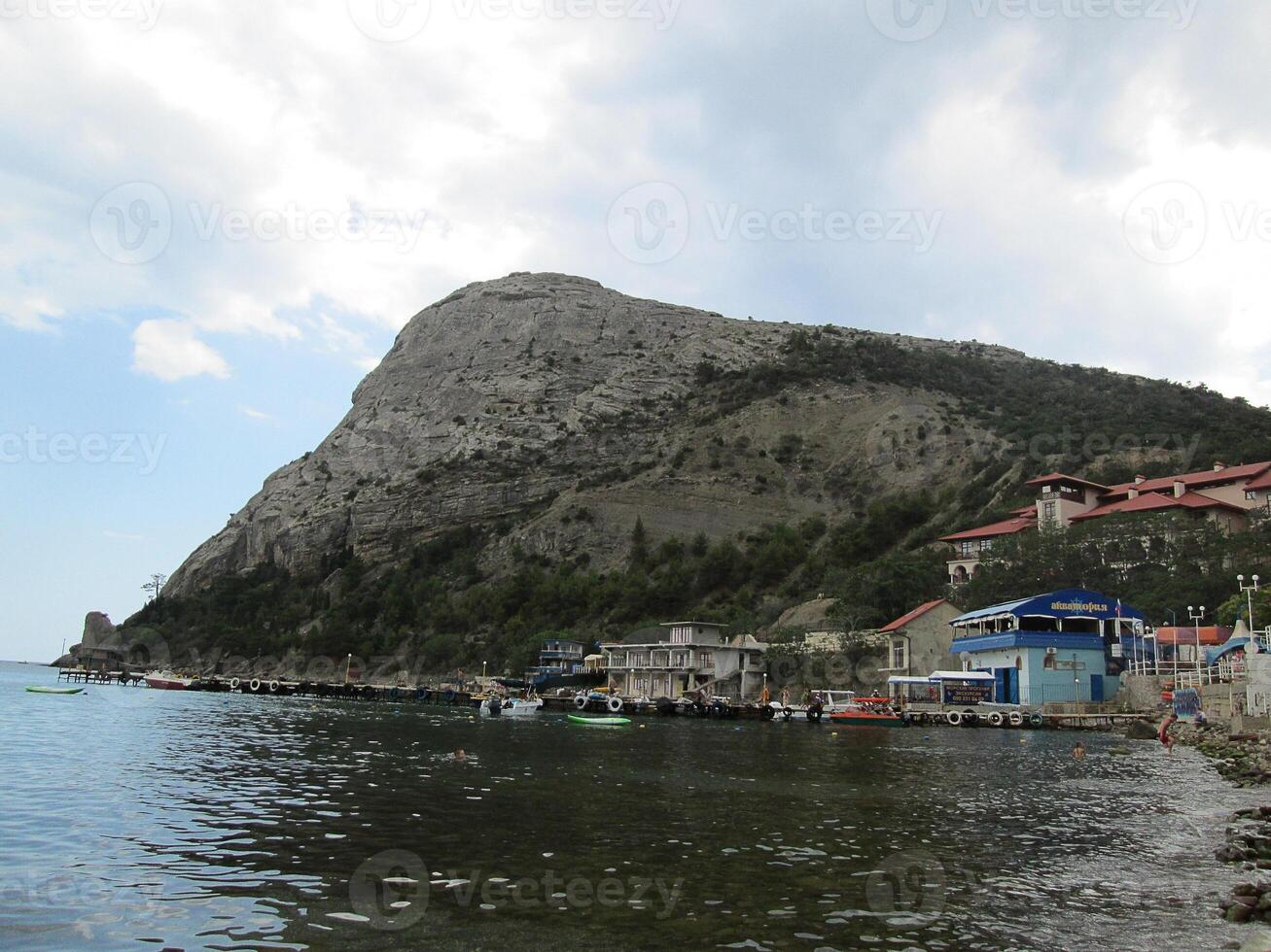 un pequeño pueblo oculto desde el mar vientos detrás un grande montaña. foto