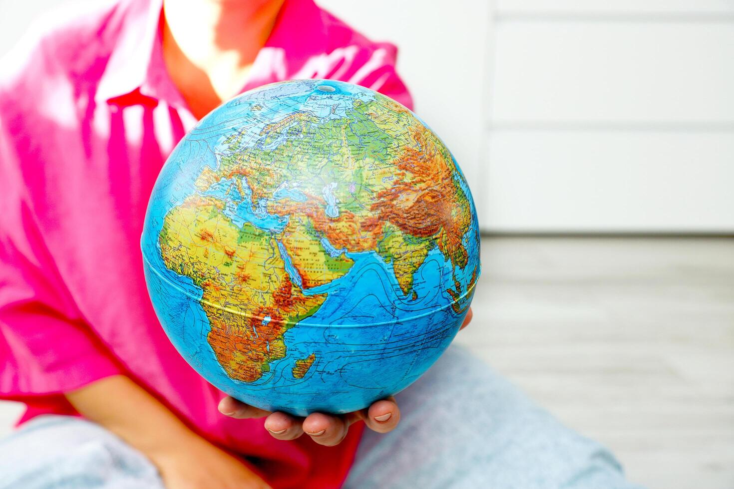 woman holding out physical globe photo