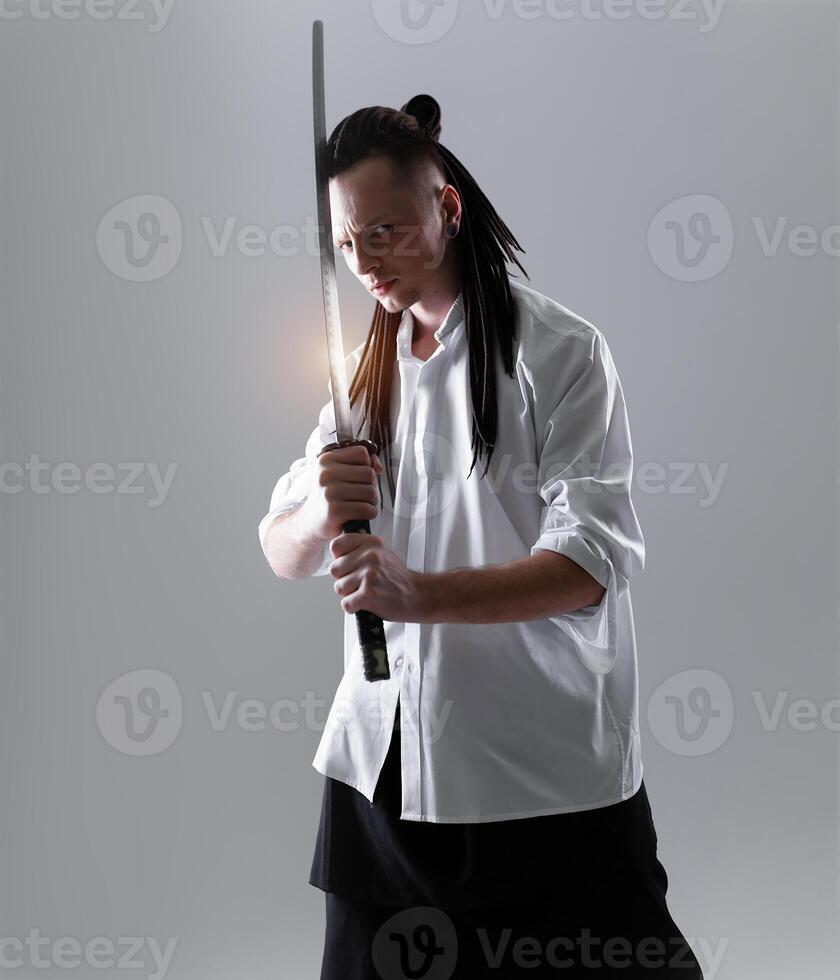 Young man holding a samurai sword. Glamour photo. photo