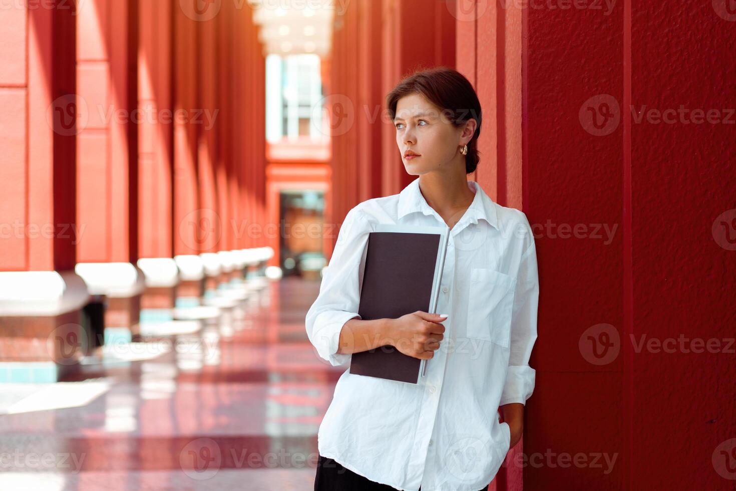 Businesswoman portrait. Caucasian female business person standing outdoor with business paper document holder. photo