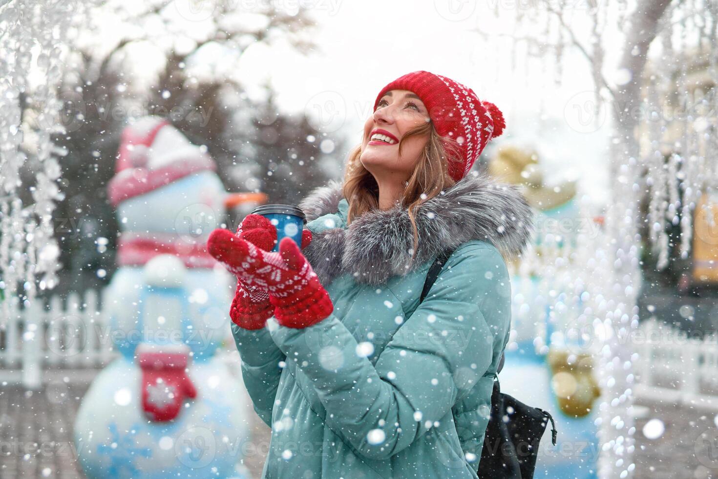 Beautiful lovely middle-aged girl with curly hair warm winter jackets stands ice rink background Town Square. photo