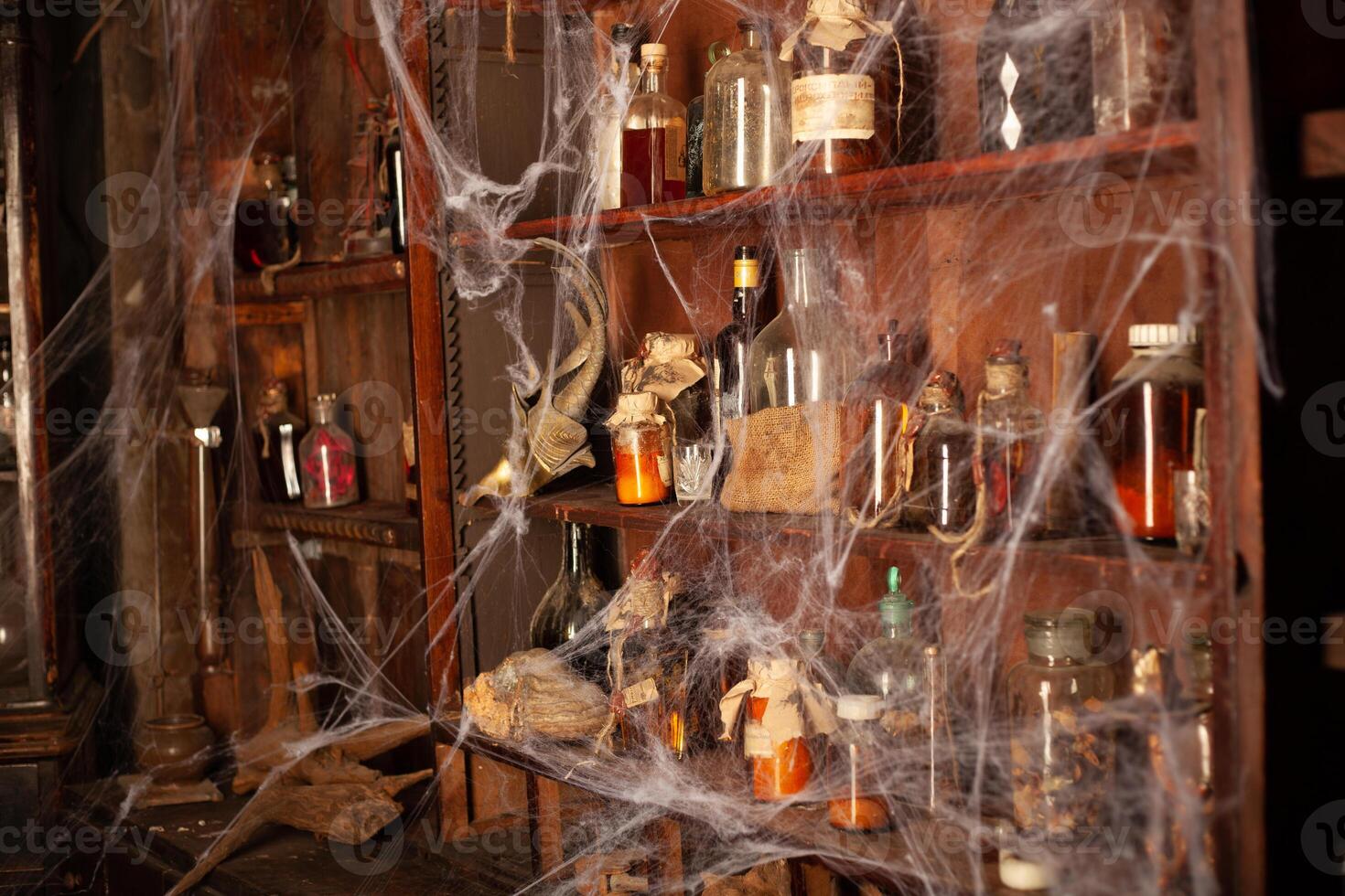 Halloween background Shelves with alchemy tools Skull spiderweb bottle with poison candles photo