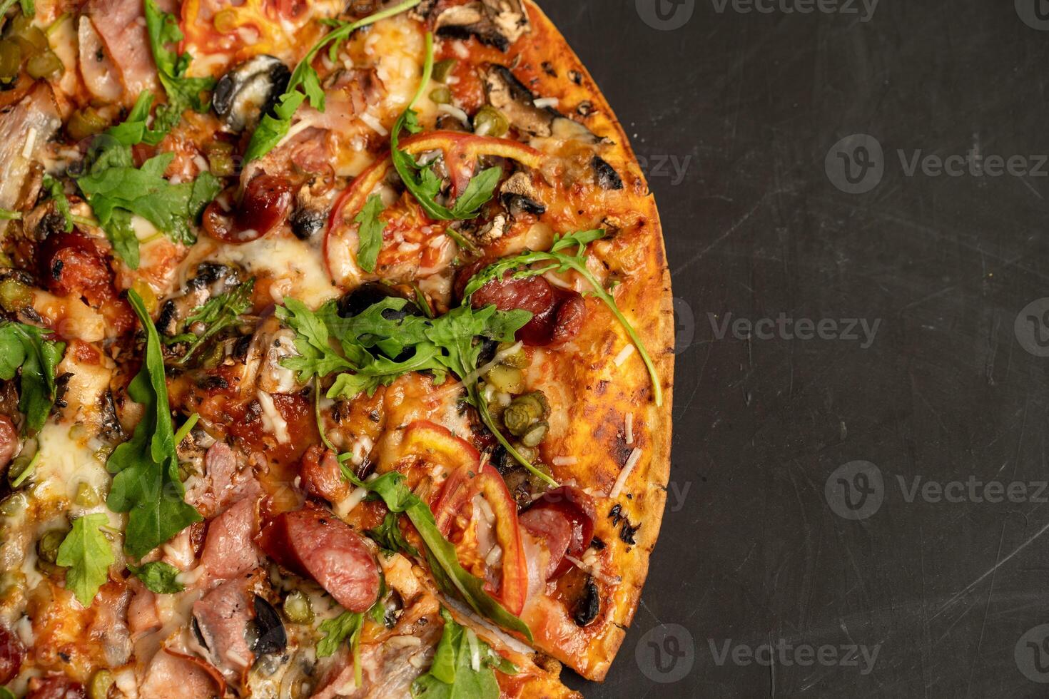 Appetizing pizza with smoked sausages bacon meat tomato cheese arugula photo