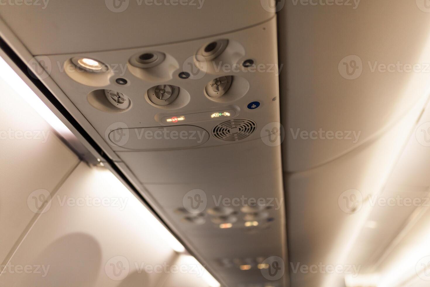 Overhead console in the modern passenger aircraft. air conditioner button and lighting switch photo