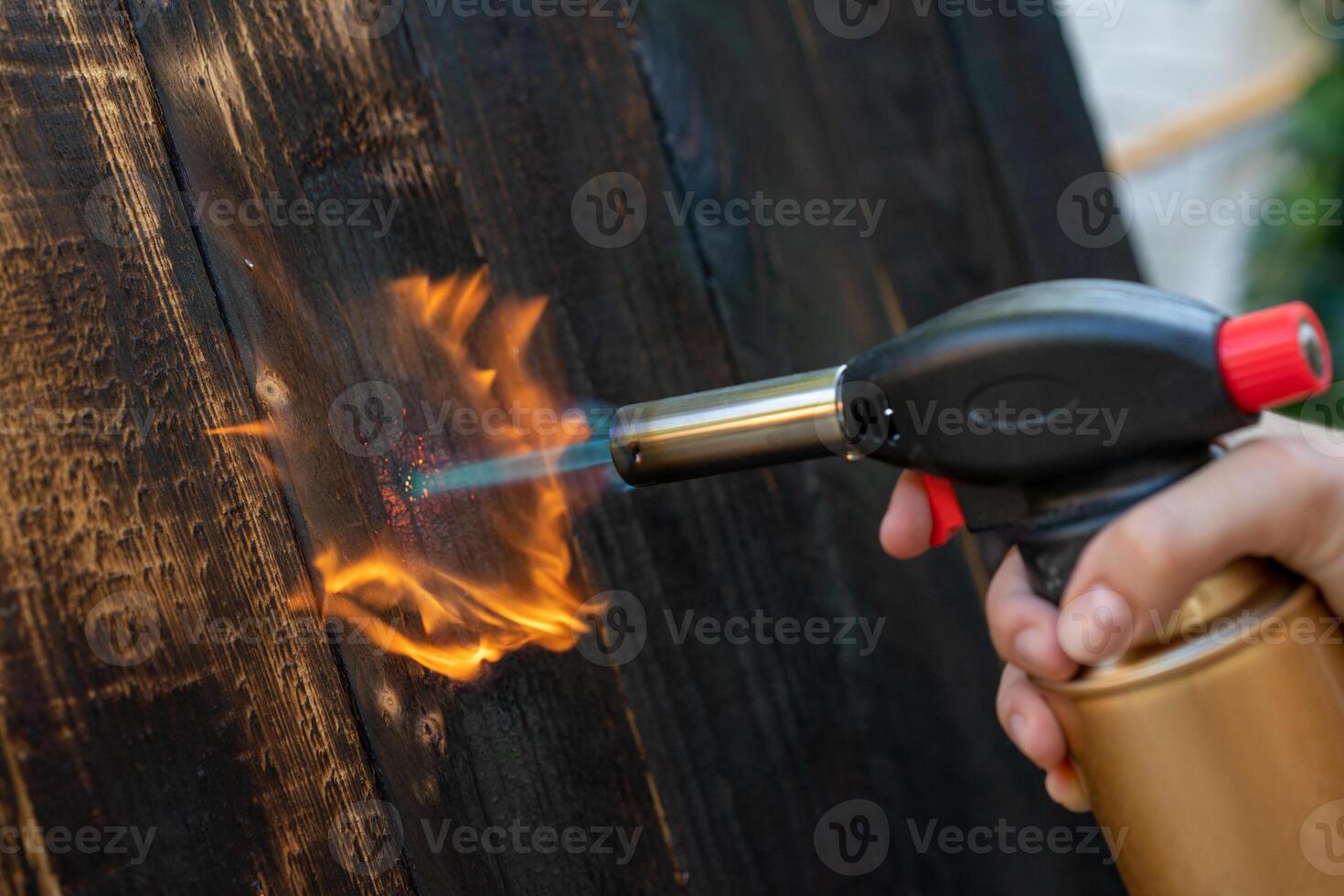 Professional carpenter using old traditional japanese technique. Burning wood planks with gas burner photo