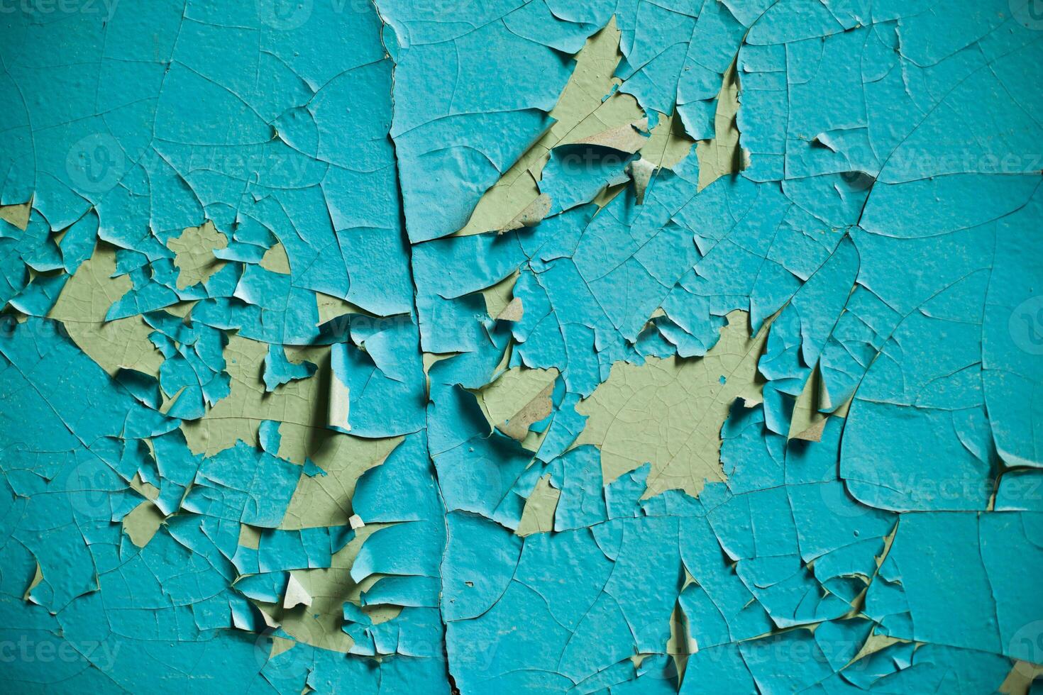 Cracked wall with old layers of paint in abandoned house photo