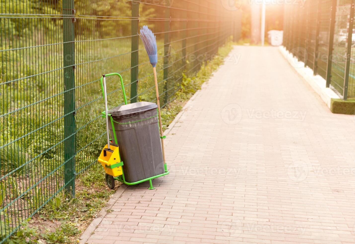 A bucket for cleaning outdoors near a fence photo