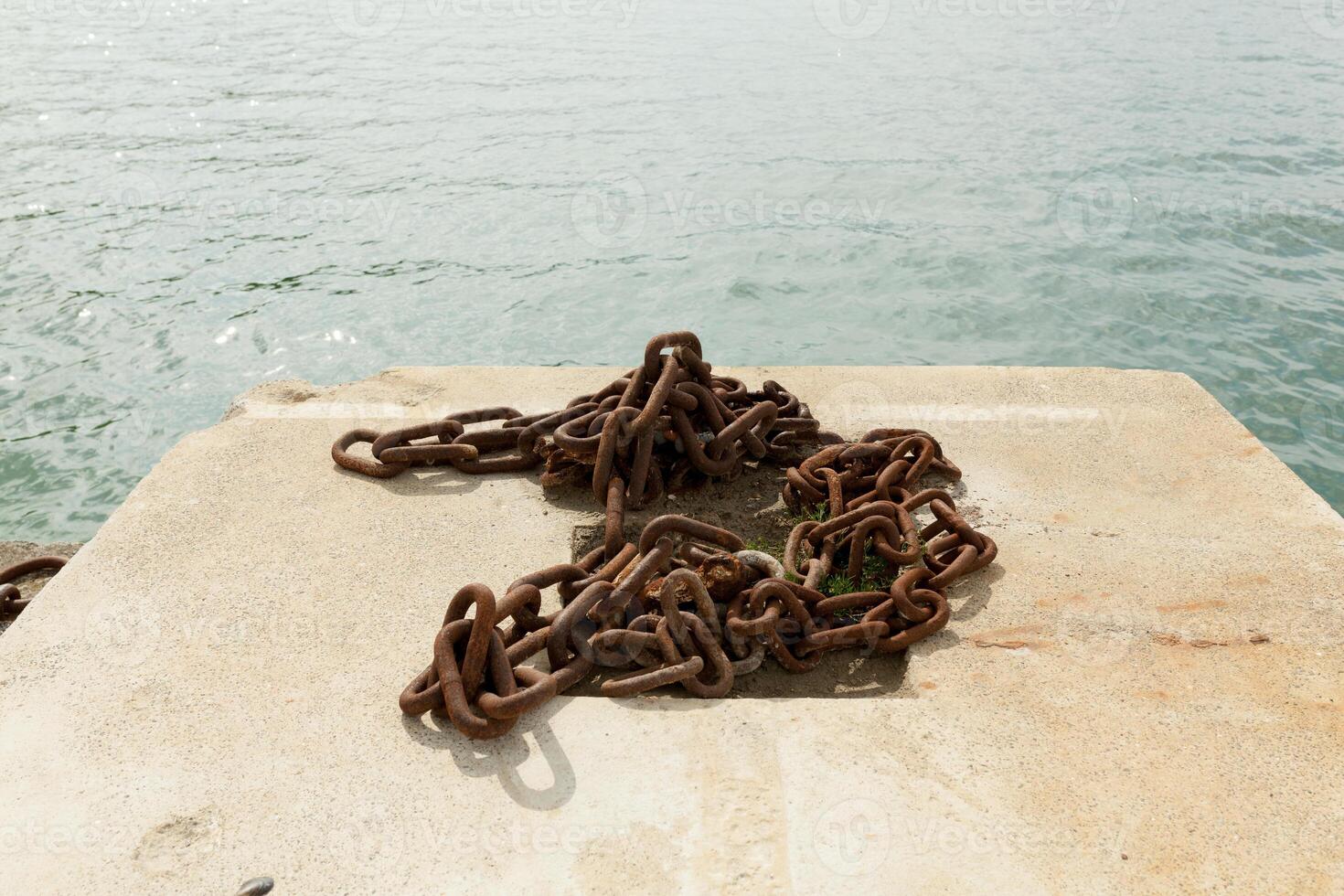 Old rusty chain at sea port close-up photo