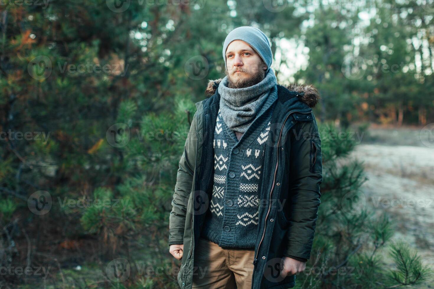 Portrait brutal bearded hipster man in the forest photo