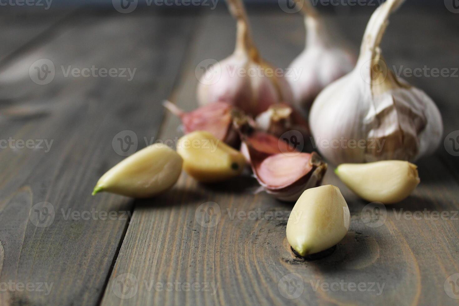 Peeled garlic cloves on gray background close-up. Spicy ingredients in cooking. Garlic as a condiment photo