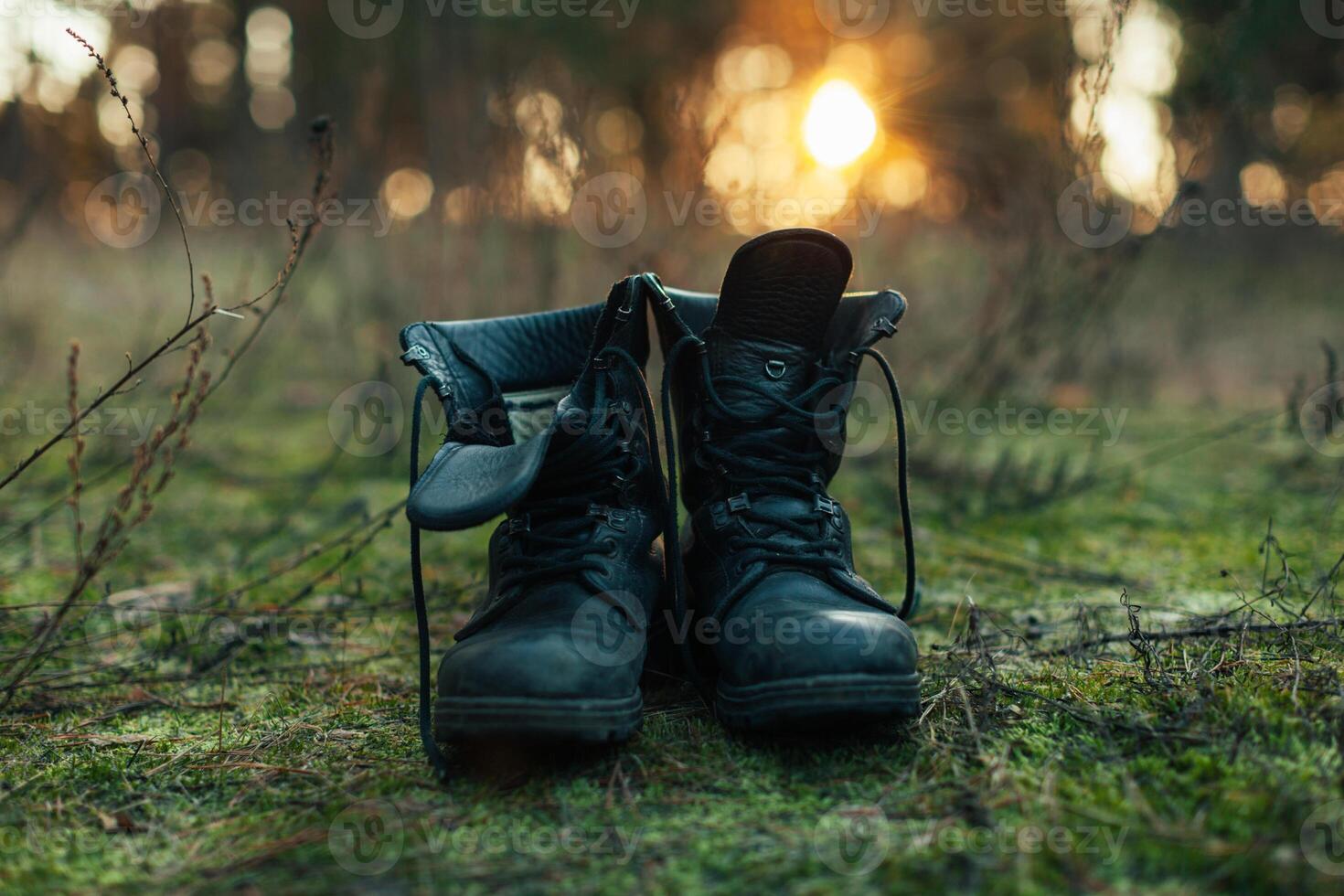 hiker old black boots standing on grass Hard travel concept photo