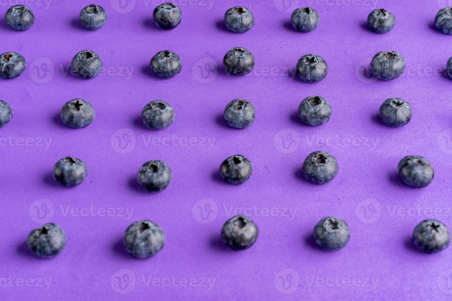 Colorful fruit pattern of blueberries on purple background. Top view. photo