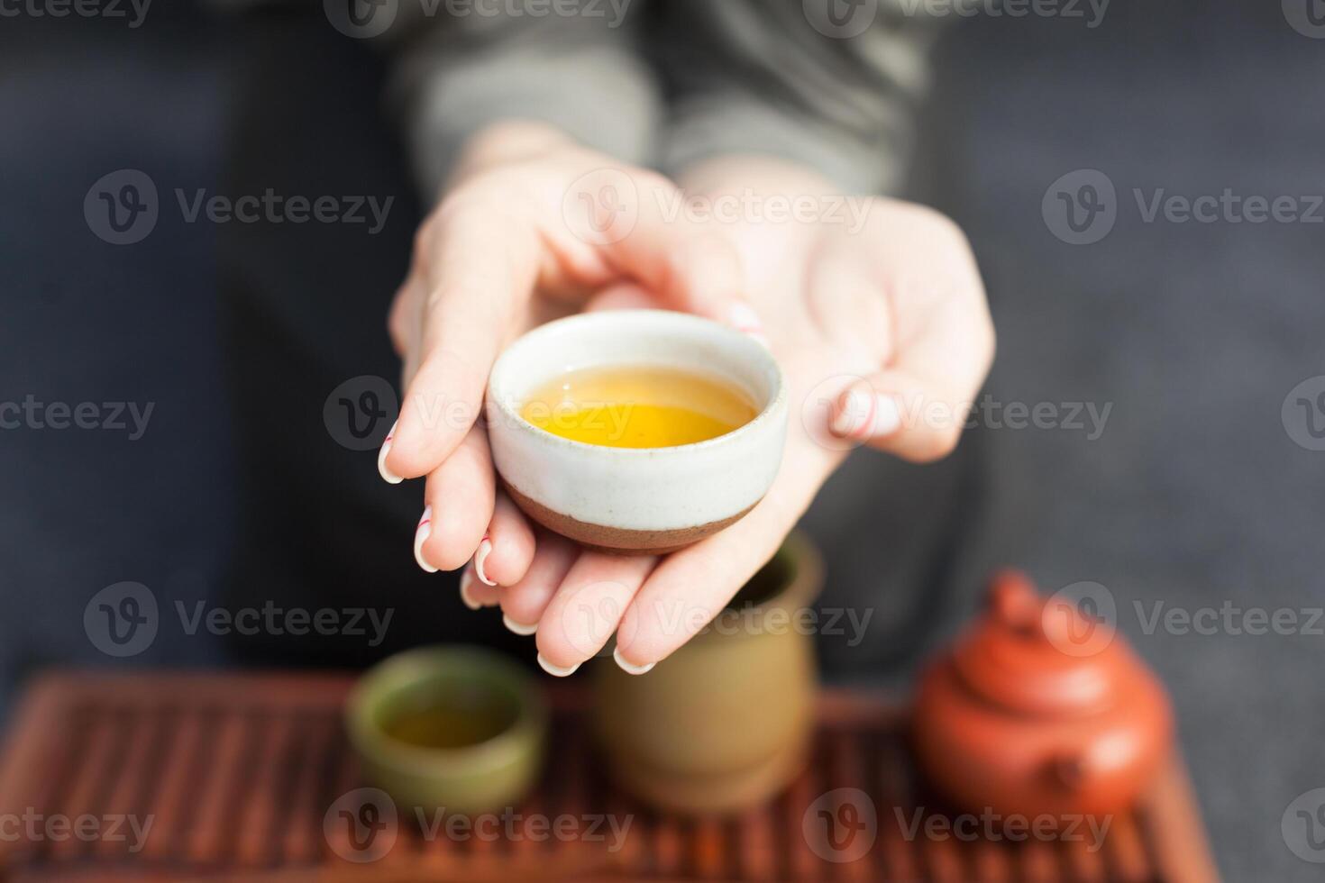 Woman offers hot tea in a vintage ceramic cup. photo