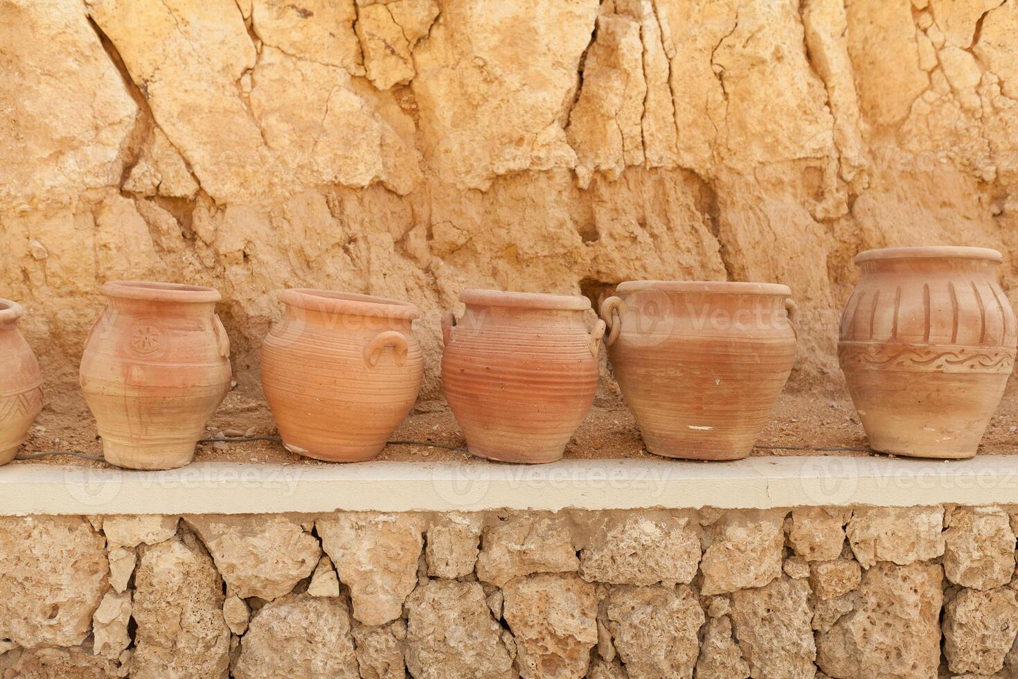 many large clay pots standing in a row photo