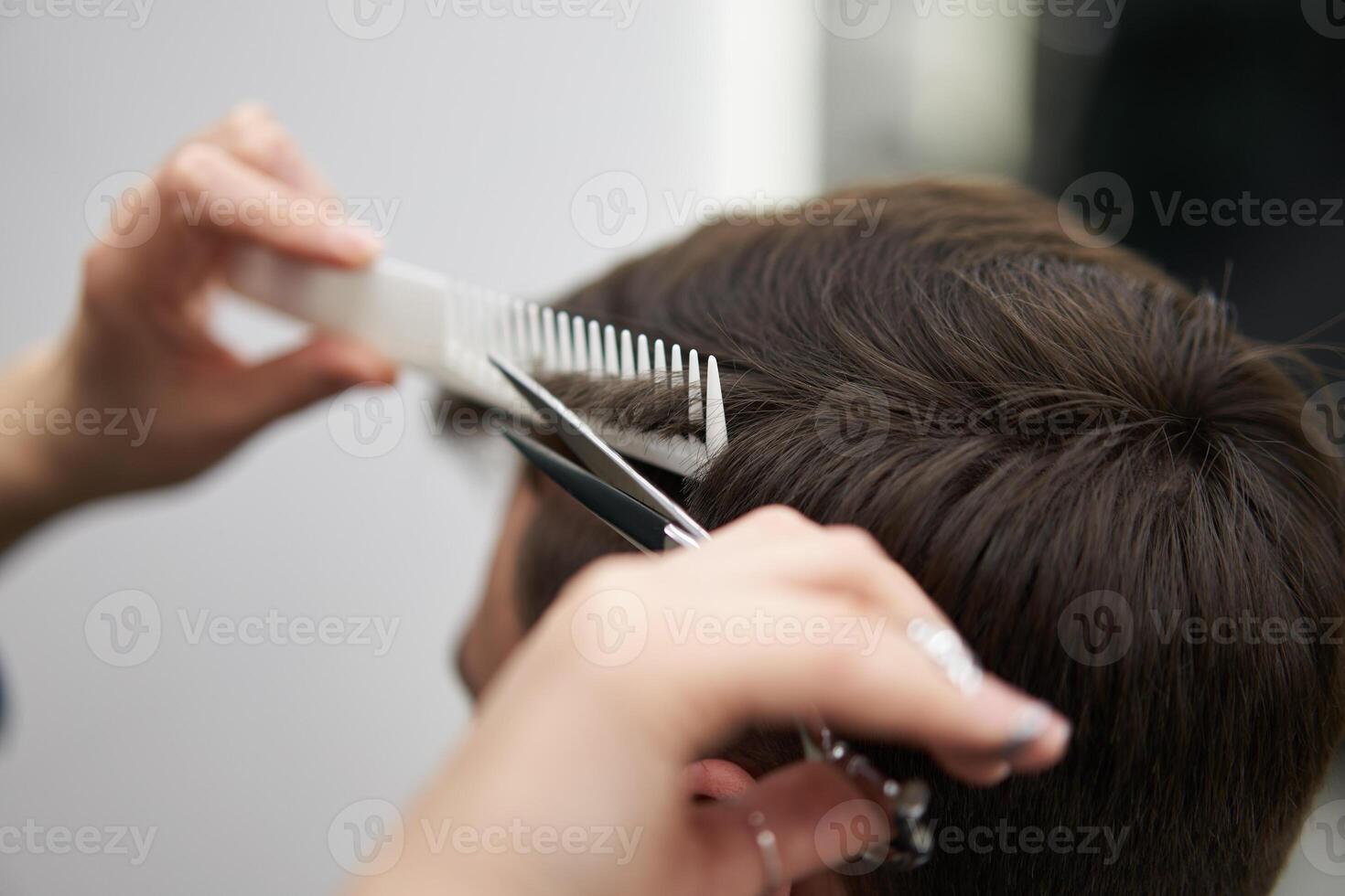 Beautiful caucasian woman hairdresser doing hairstyle to client. photo