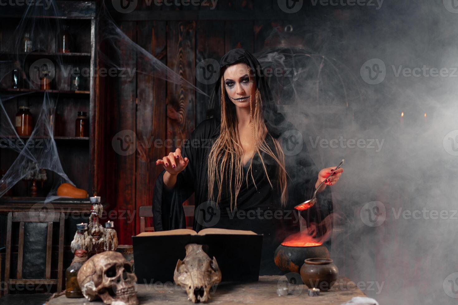 Víspera de Todos los Santos, bruja utilizar magia libro y caldera preparar veneno o amor poción foto