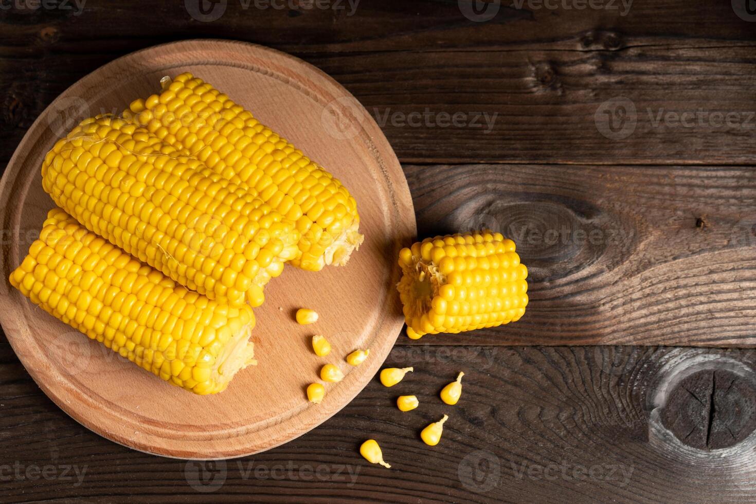 Corn cob with lies on cutting board wooden table background. photo