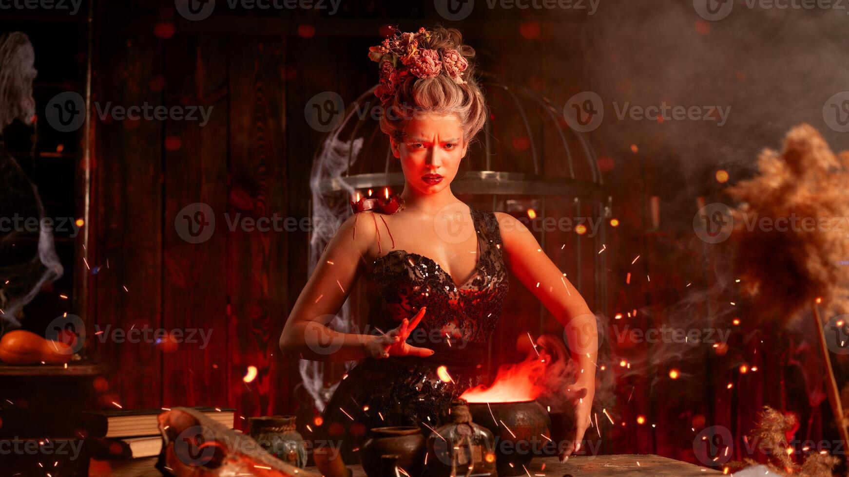 Witch with cauldron. Beautiful young woman conjuring, making witchcraft photo
