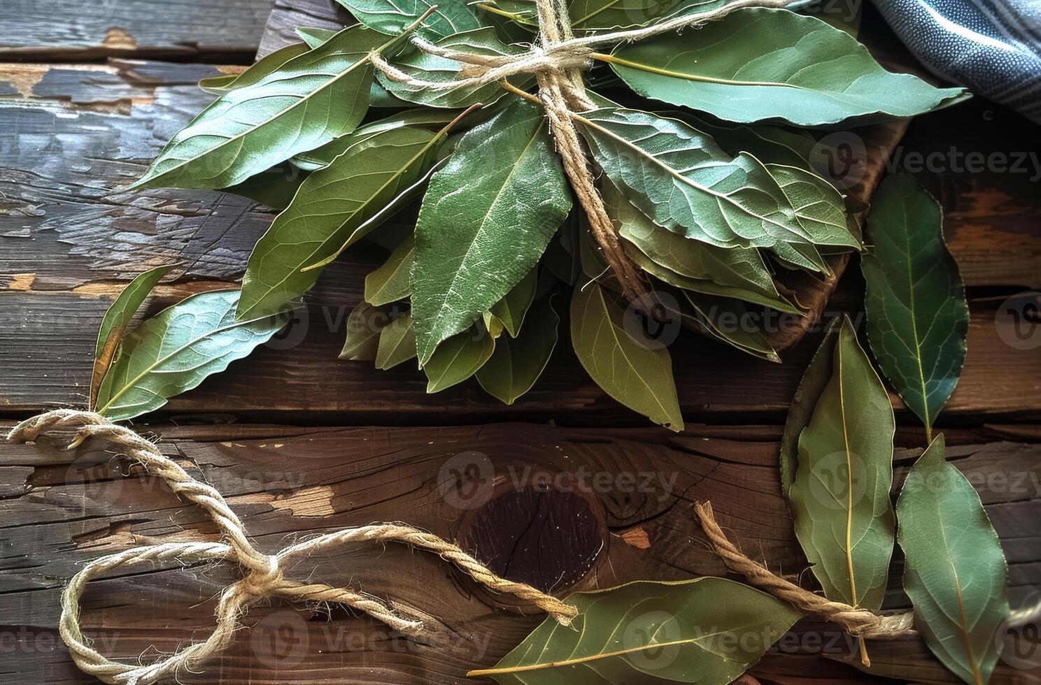 AI generated Bay leaves are tied with rope on wooden table photo