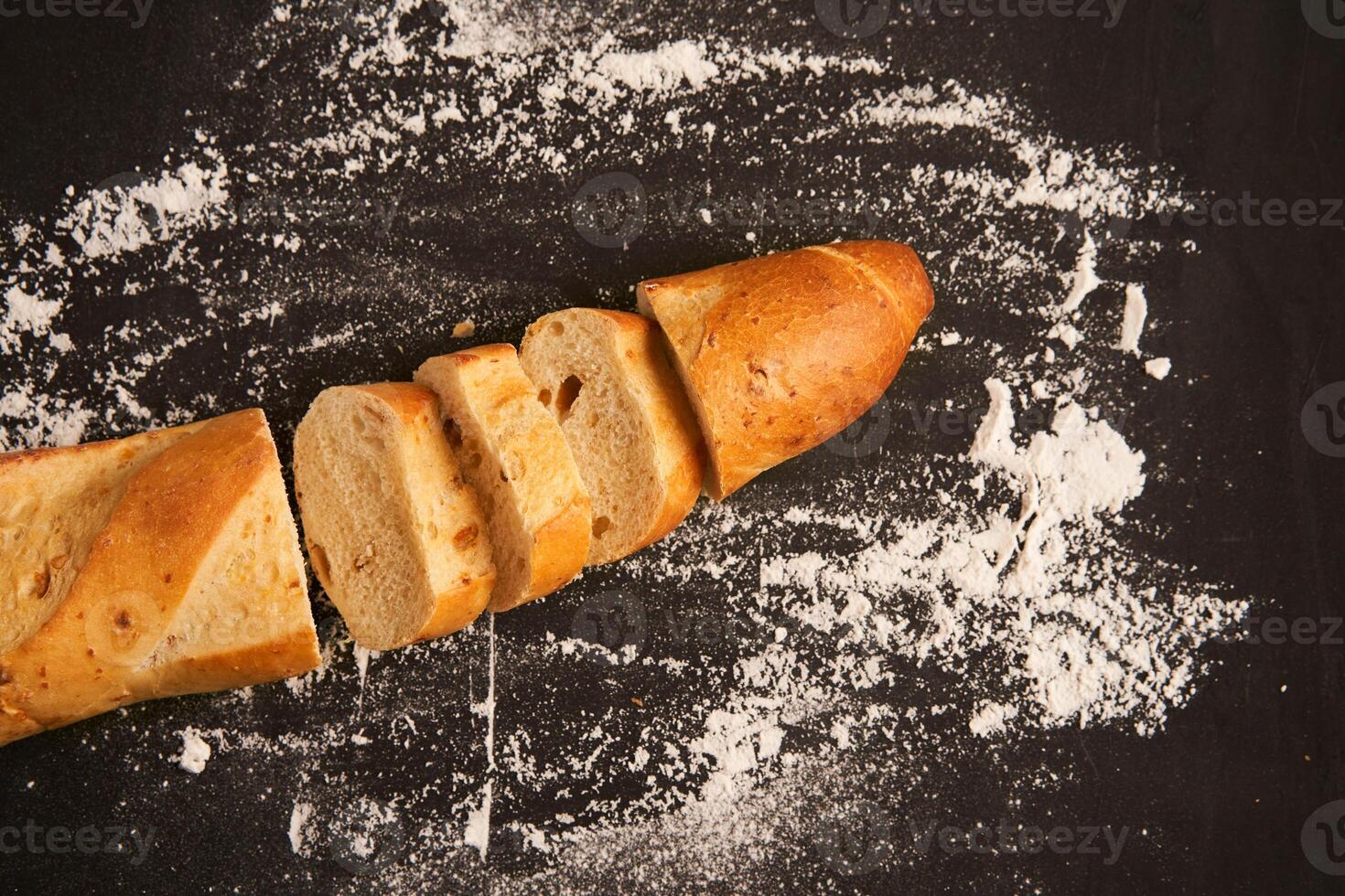 one sliced french baguettes lie on an old wooden table with free space for text photo