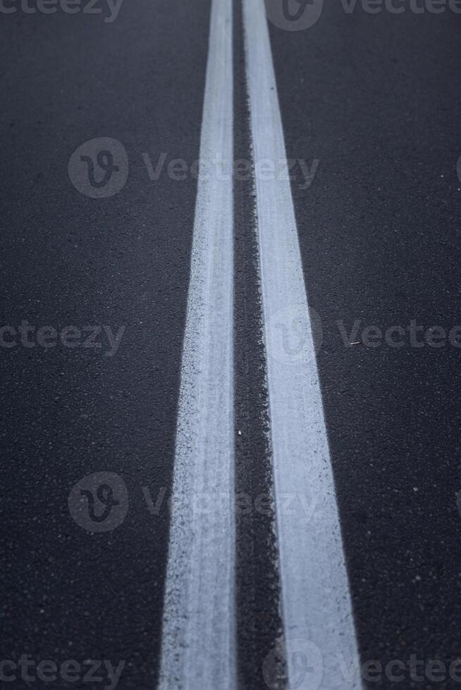 Asphalt road with marking lines white stripes. Two solid lines photo
