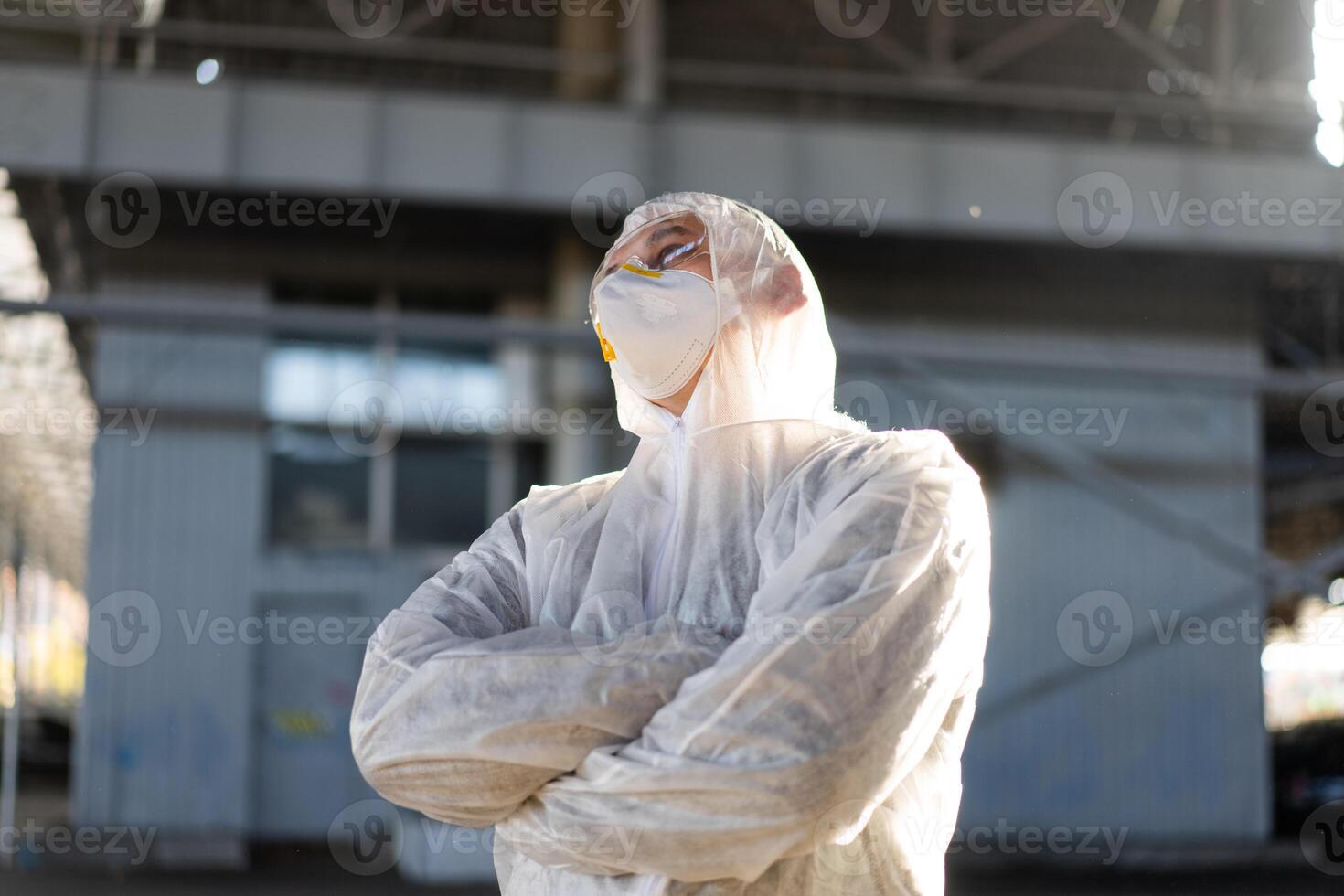 COVID-19 coronavirus doctor standing hospital parking dressed white protective overalls hazmat suit. photo