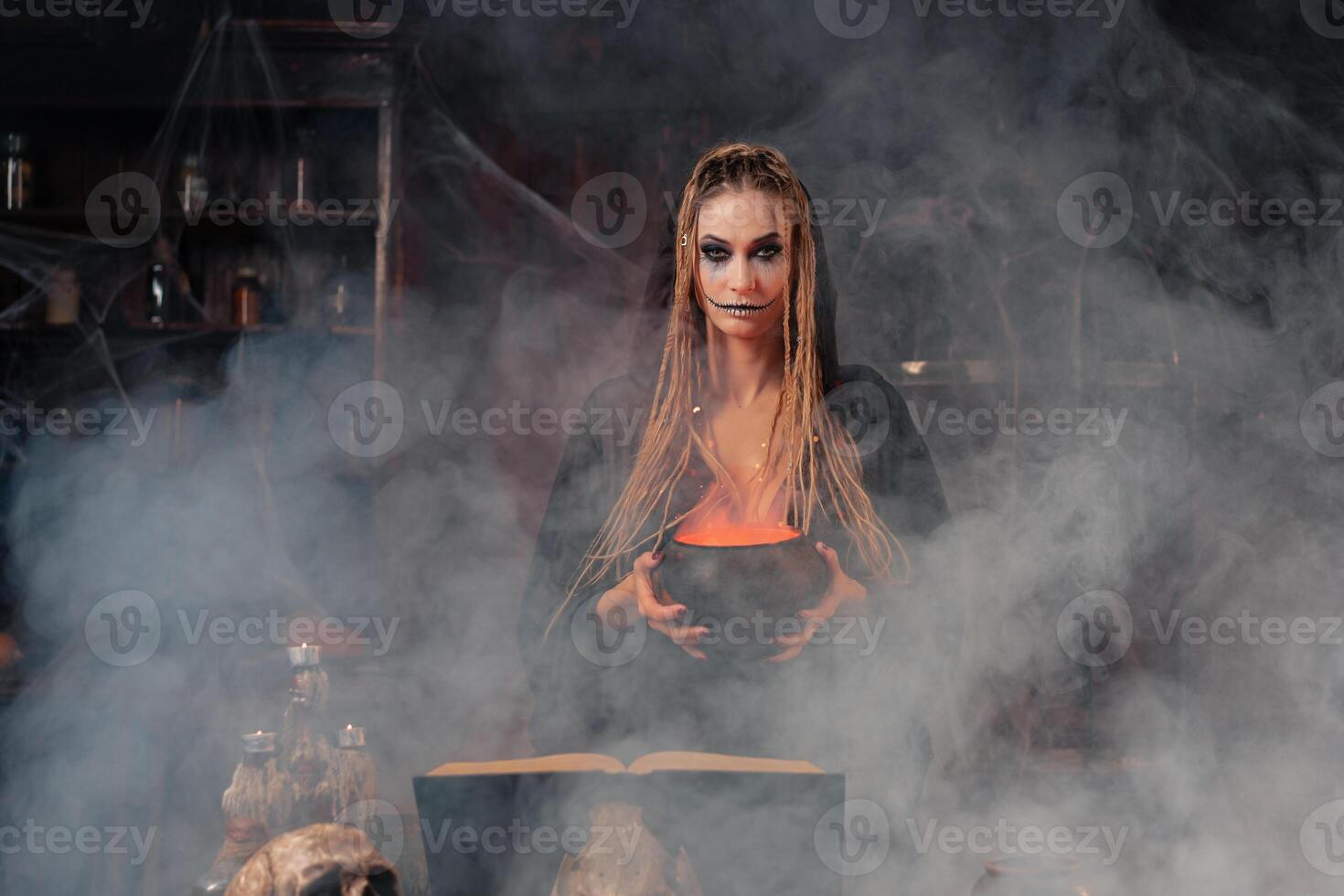 Halloween, witch use magic book and cauldron prepare poison or love potion photo