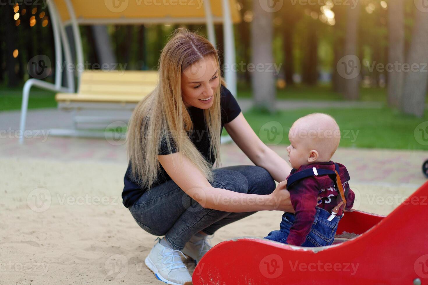 Beautiful young mother walks with her little son in a summer park photo