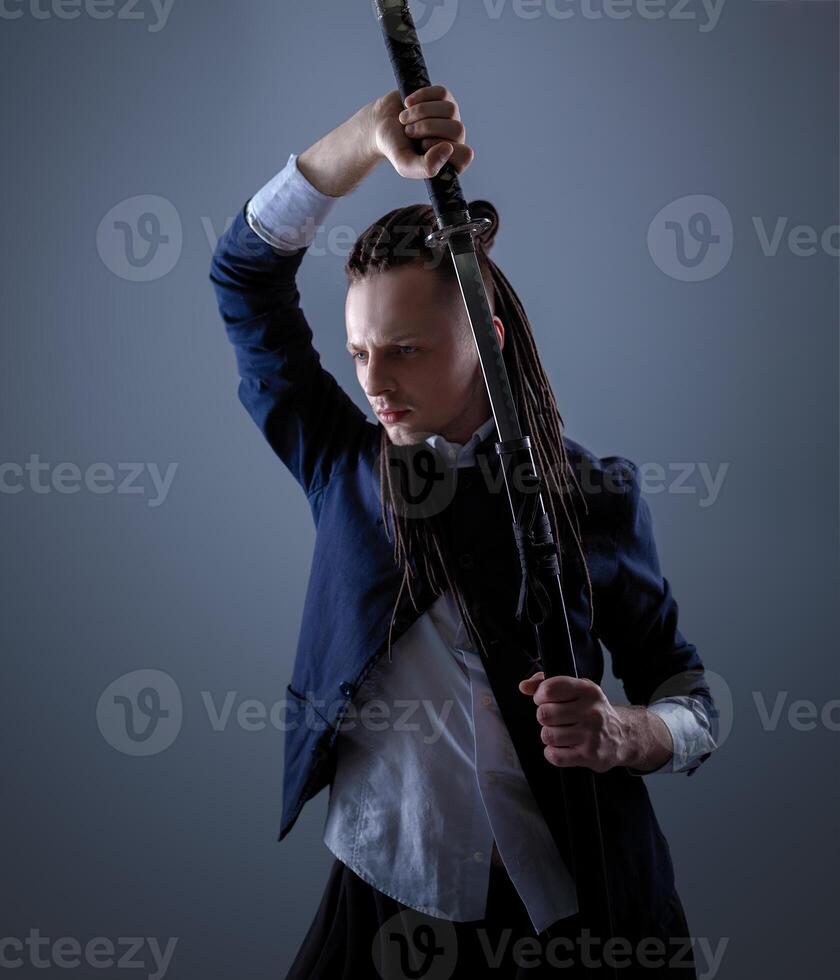 Young man holding a samurai sword. Glamour photo. photo