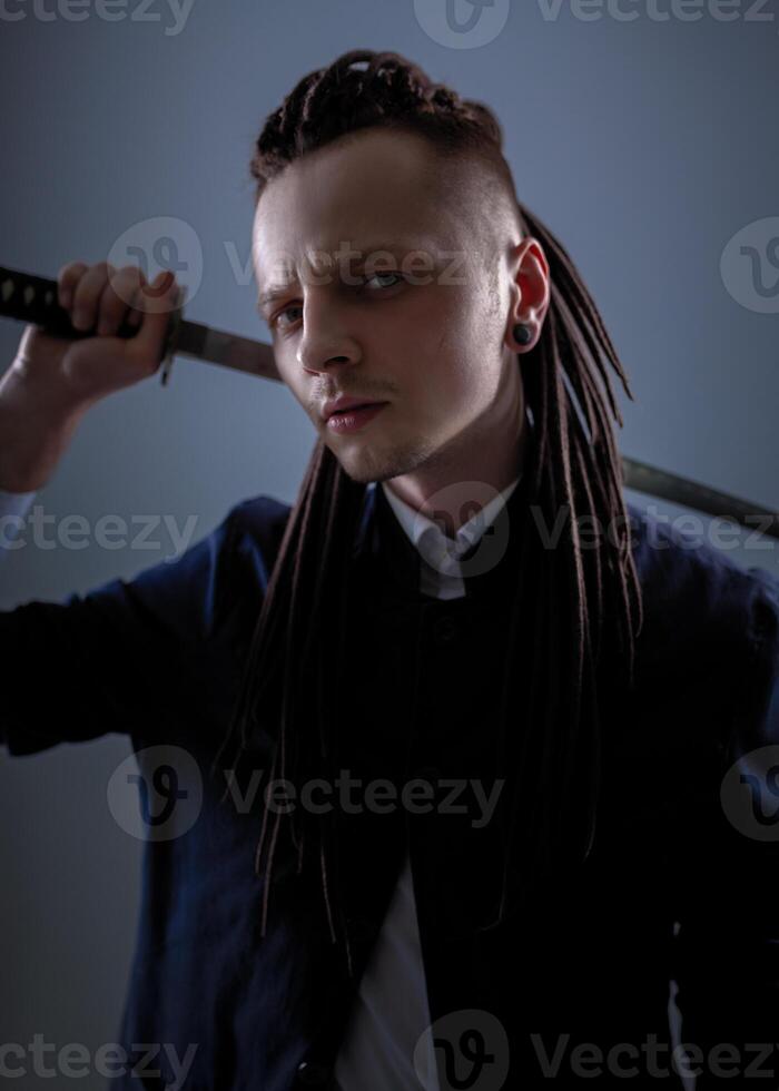 Young man holding a samurai sword. Glamour photo. photo