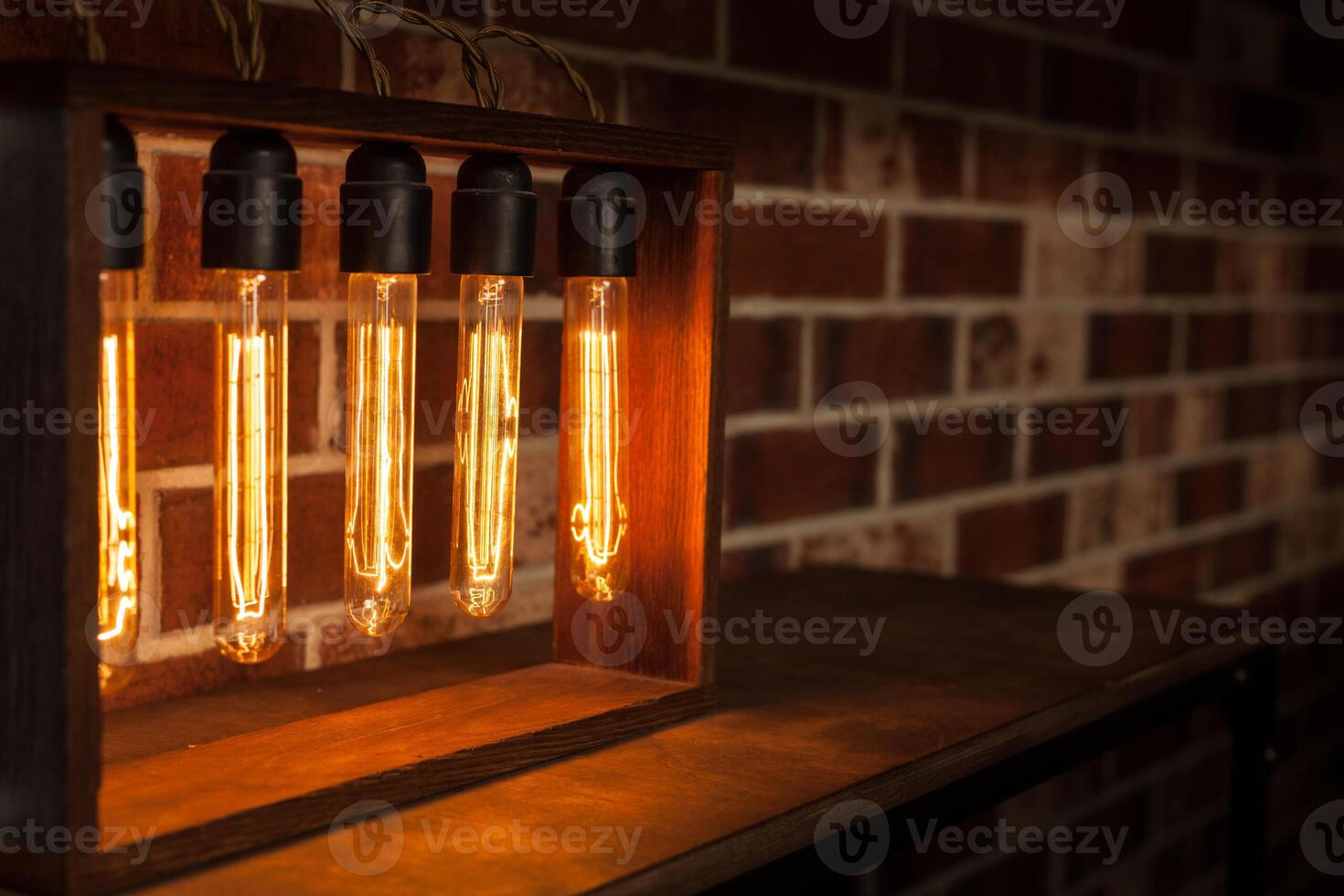 Light bulb lamp on dark red brick background with hotspot close up loft photo