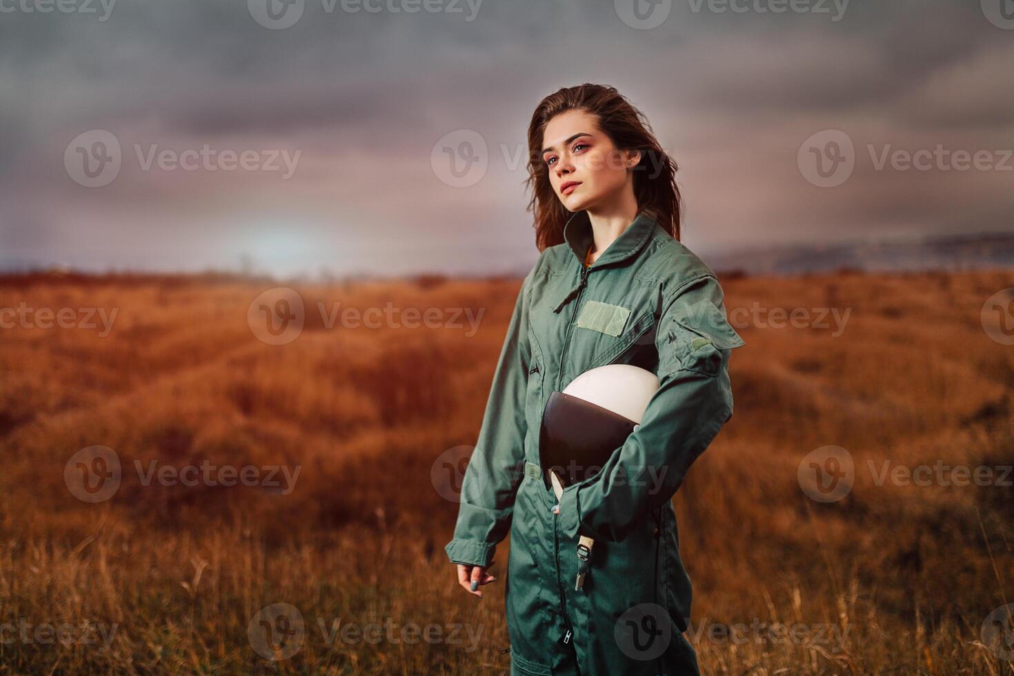 portrait of young beautiful girl pilot in the sunset field photo