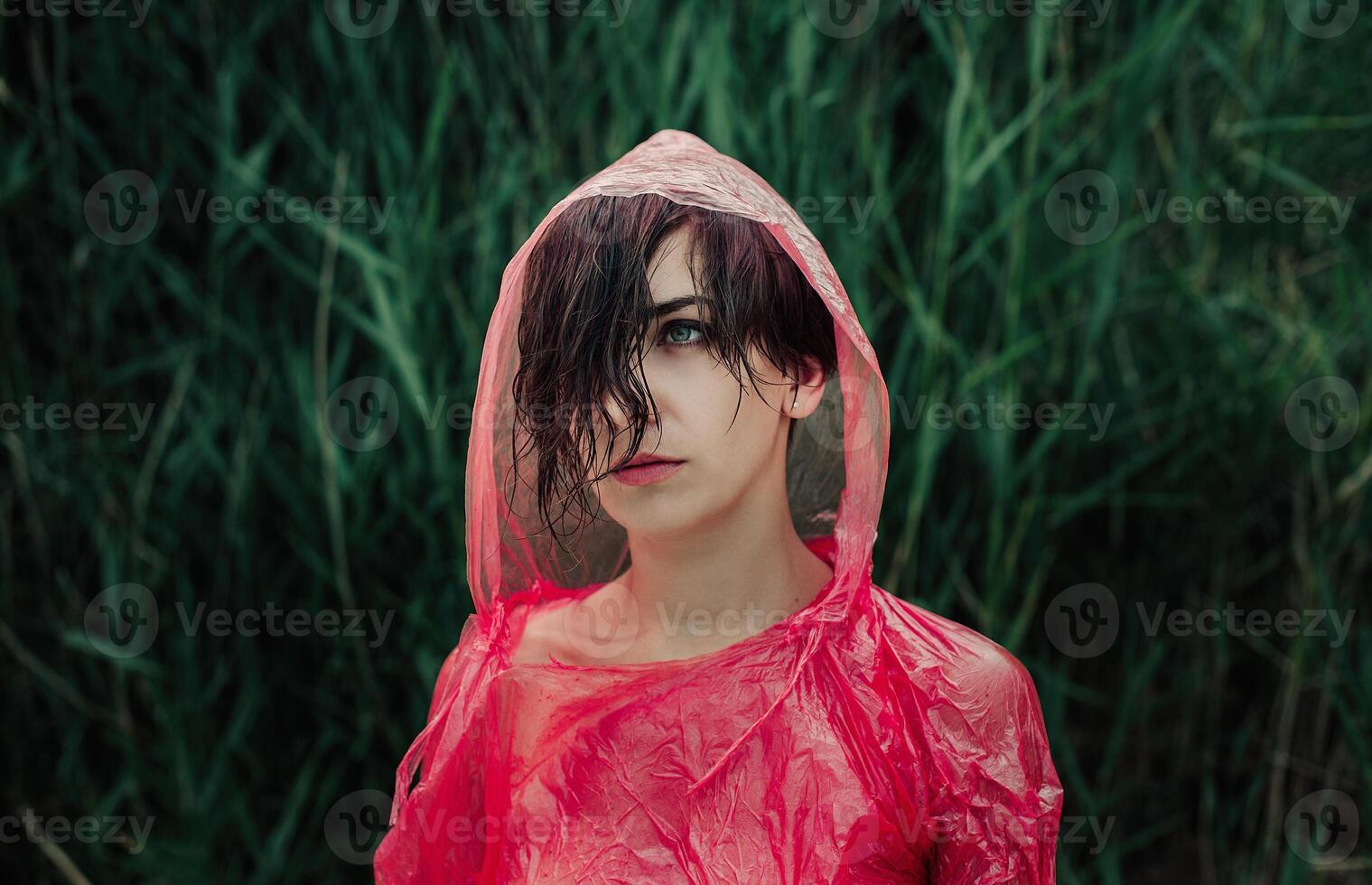 The portrait of girl in red raincoat under the rain. photo
