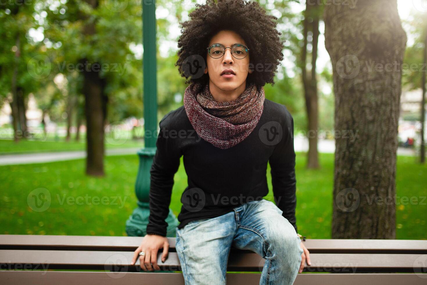 Young Afro american young businessman or student wearing black turtleneck sweater and scarf and having curly dark hair. Concept of stylish and fashionable look photo