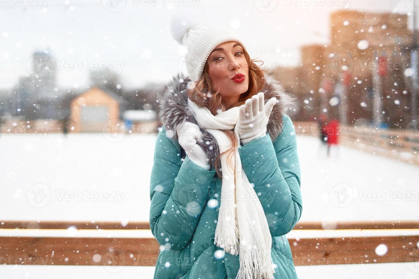 Beautiful lovely middle-aged girl with curly hair warm winter jackets stands ice rink background Town Square. photo