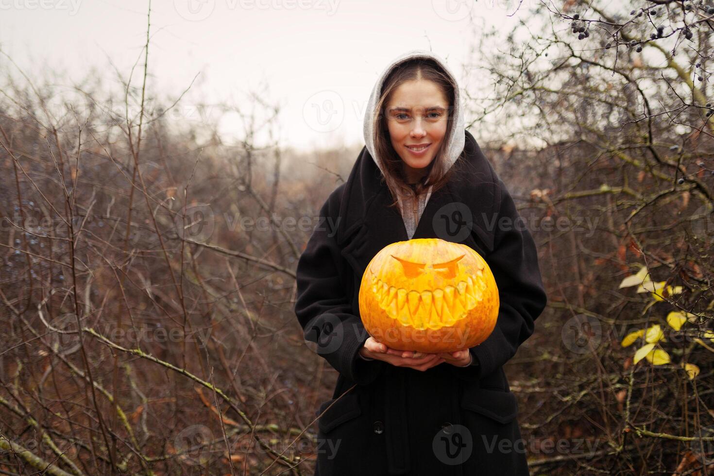 Young smiling woman holding the halloween pumpkin photo