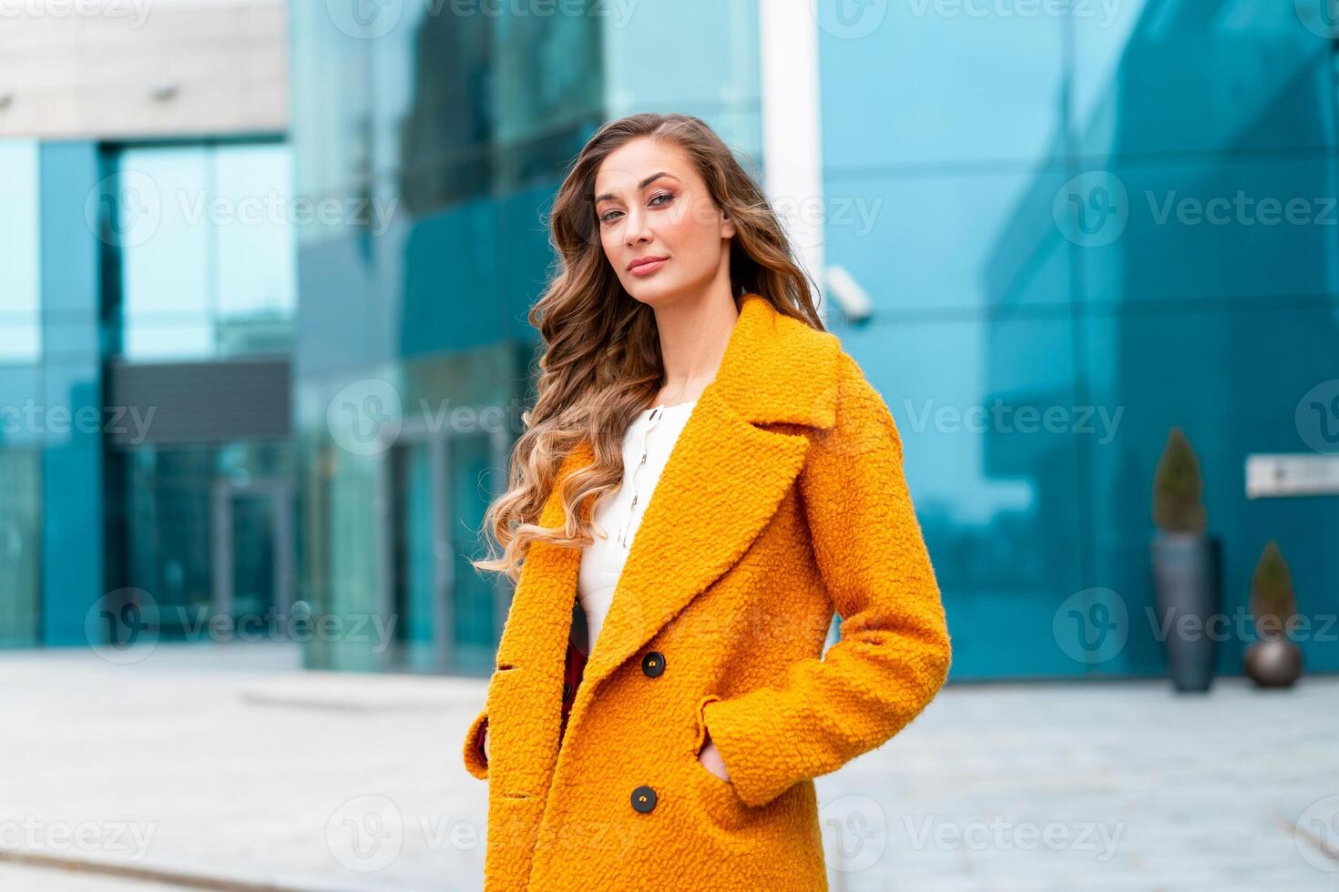 Business woman dressed yellow coat standing outdoors corporative building background photo
