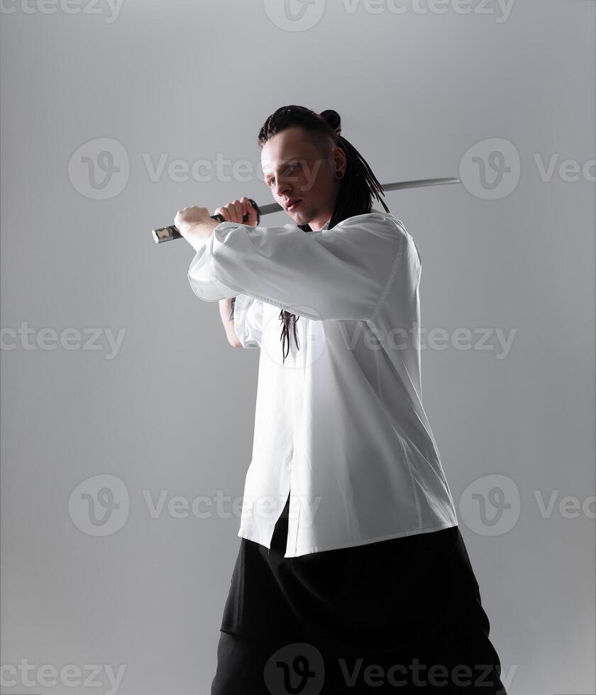 Young man holding a samurai sword. Glamour photo. photo
