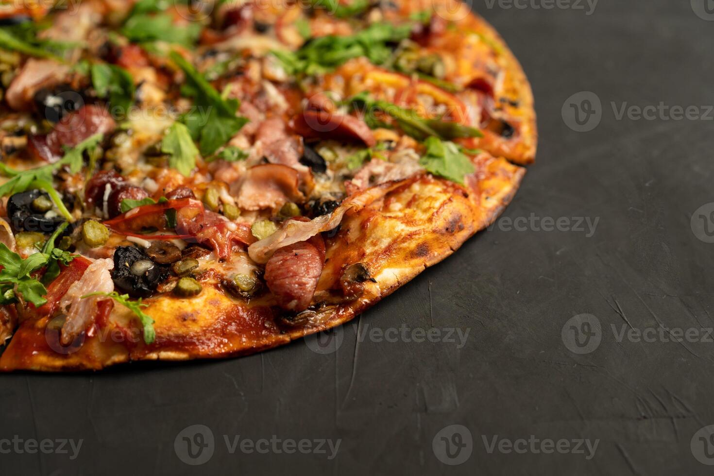 Appetizing pizza with smoked sausages bacon meat tomato cheese arugula photo