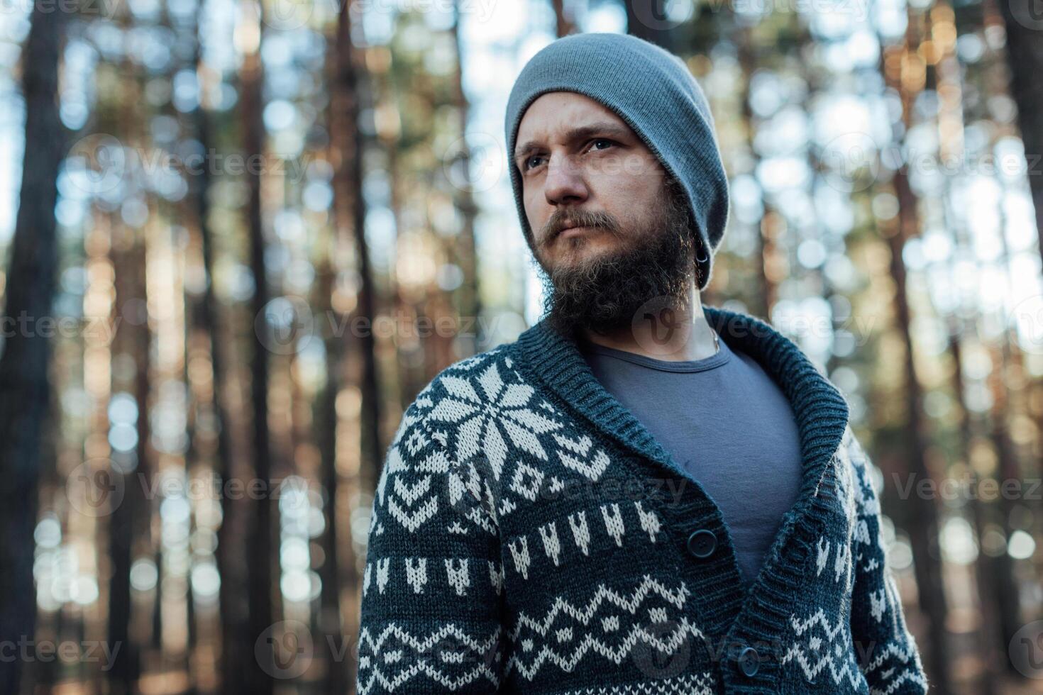 a young man with a beard walks in a pine forest. Portrait of a brutal bearded man Autumn forest photo